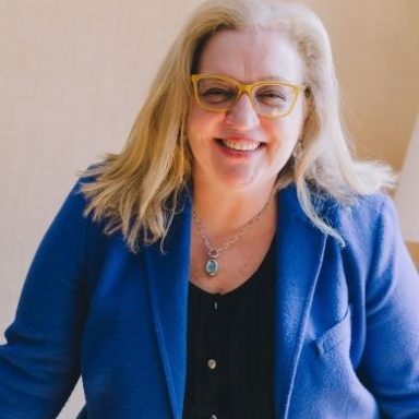 Photo of agent Elissa Abreu smilling with a blue blazer.