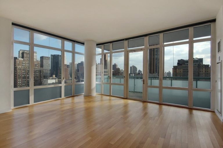 Nice corner living room showing the double corner all glass with a nice wood floor. The apartment if empty.